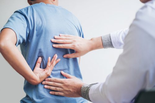 Doctor Examining Patient with Back Pain